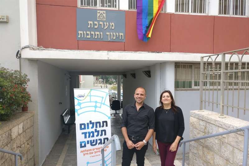 אילנה טרוק ויוסי שלום, ודגל הגאווה על בניין אגף החינוך | צילום: ראובן כהן, עיריית חיפה