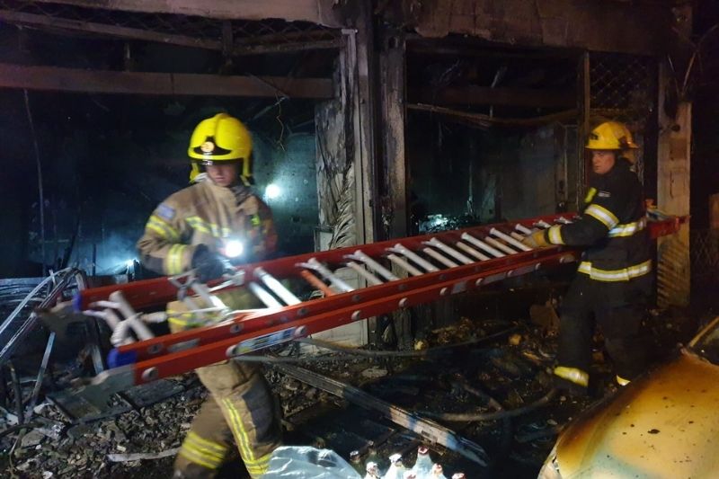 צוותי הכיבוי בחנות שנשרפה | צילום: כבאות והצלה